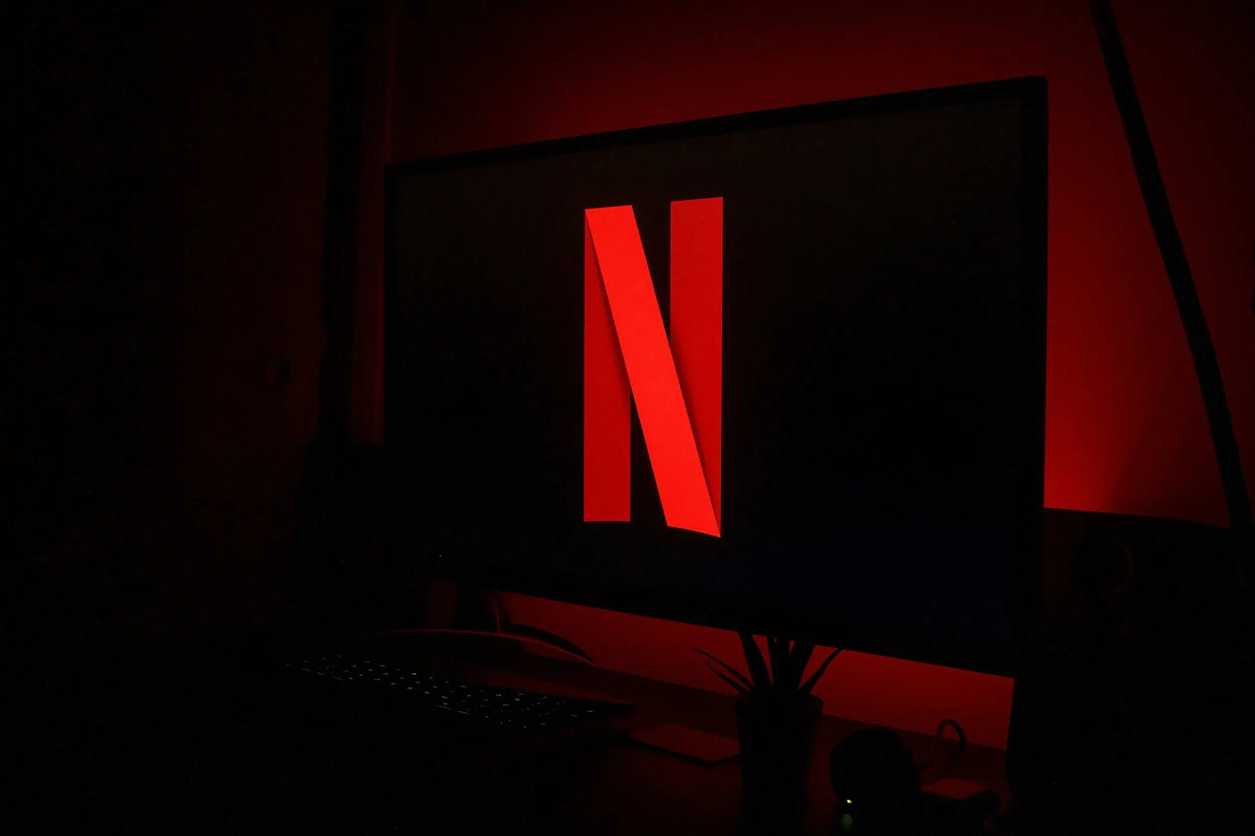 Telecomando davanti a uno schermo TV con il logo Netflix, simbolo delle nuove uscite serie tv di luglio 2026